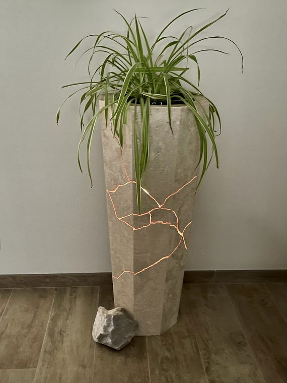 Totem Faille d'Or, jardinière en travertin parcourue de failles lumineuses — photo d'atelier